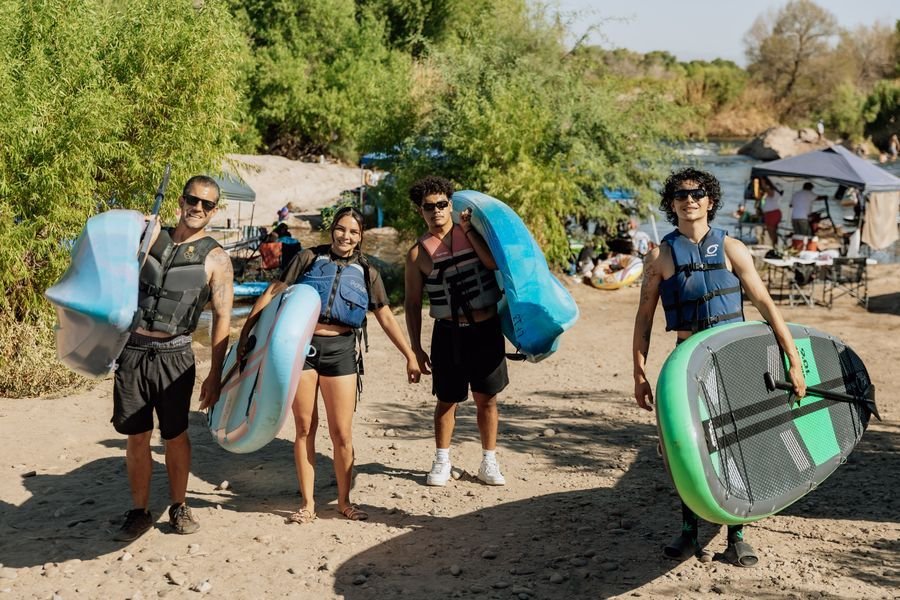 A group carrying Redline paddleboards to the river