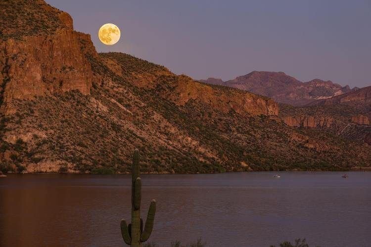Full moon rising over the cliffs above a desert lake