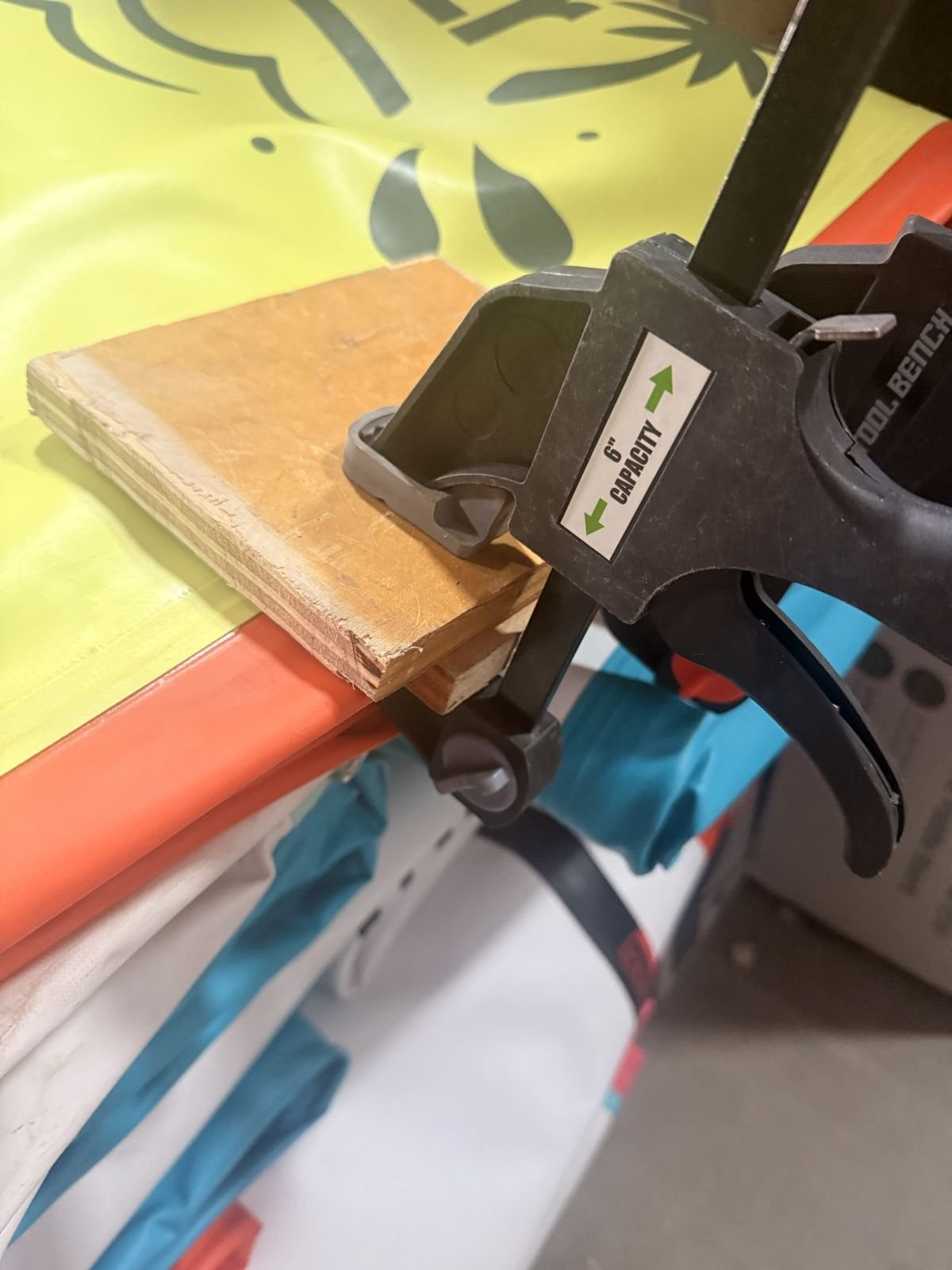 Paddleboard clamped flat between wood blocks during a patch repair at Redline